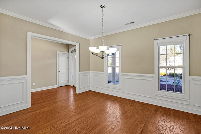 unfurnished dining area featuring hardwood / wood-style floors, a notable chandelier, and ornamental molding