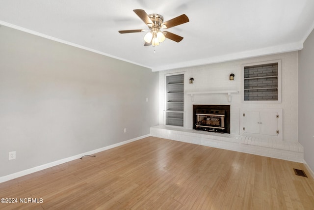 unfurnished living room with a brick fireplace, hardwood / wood-style flooring, built in features, and ceiling fan