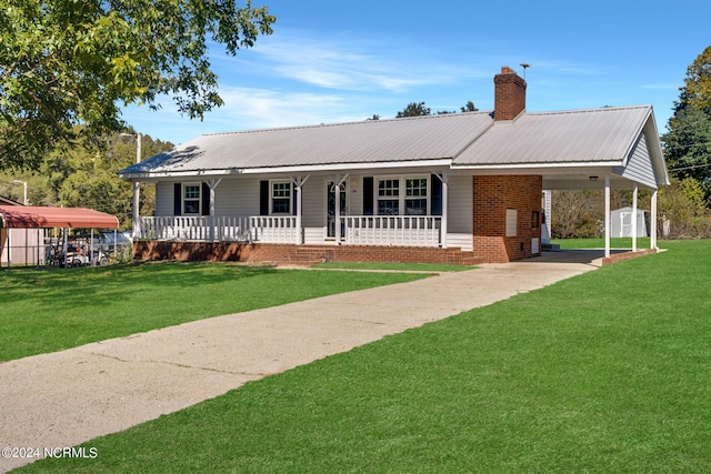 single story home featuring covered porch, a front lawn, and a storage shed