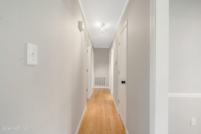 hallway featuring light hardwood / wood-style floors and crown molding