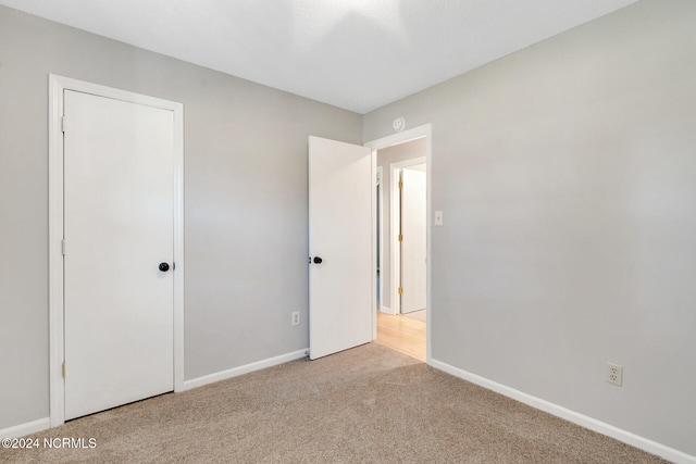 unfurnished bedroom with light colored carpet