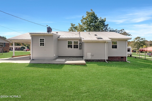 rear view of house with a lawn and a carport