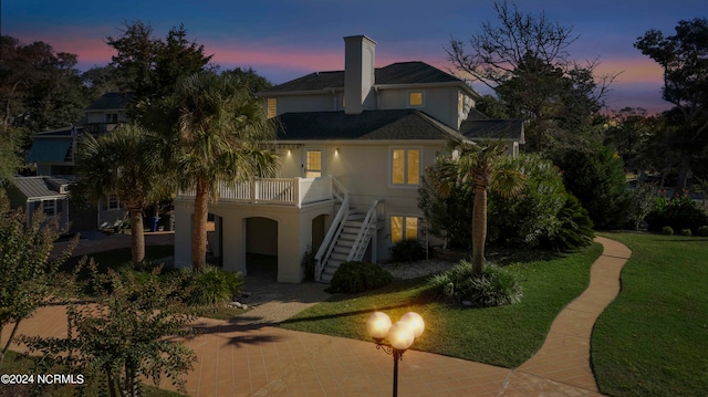 back house at dusk featuring a yard