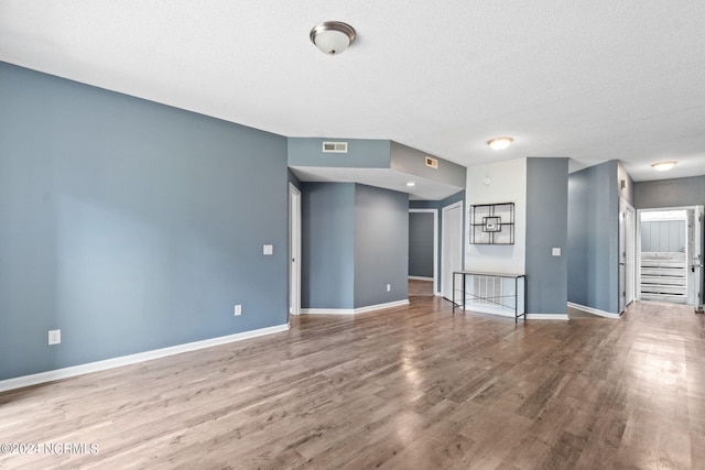 unfurnished living room with hardwood / wood-style floors and a textured ceiling