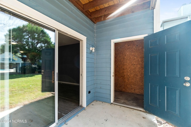 view of exterior entry with a lawn