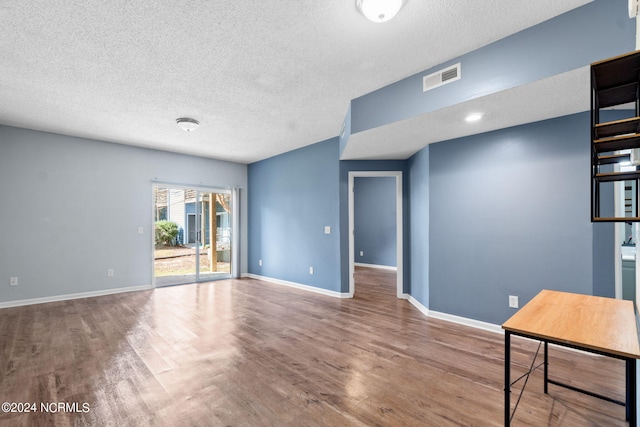 unfurnished living room with a textured ceiling and hardwood / wood-style flooring