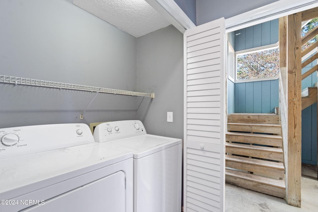 washroom with washing machine and dryer and a textured ceiling