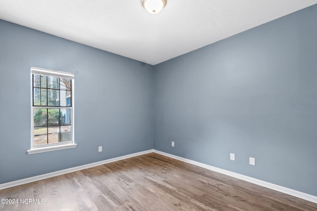 unfurnished room featuring a textured ceiling and hardwood / wood-style flooring