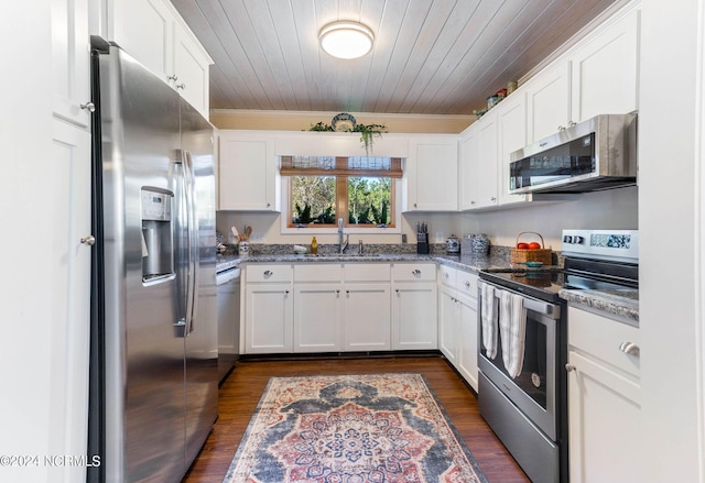 kitchen with white cabinets, stainless steel appliances, and dark stone counters