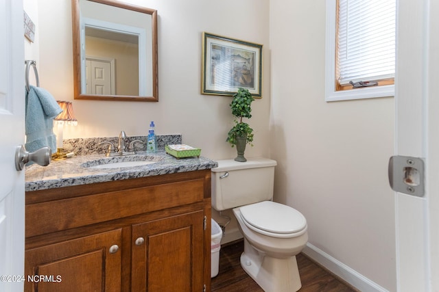 bathroom with vanity, toilet, and hardwood / wood-style flooring