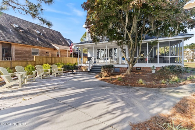 rear view of property featuring covered porch and a sunroom