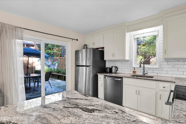 kitchen featuring white cabinetry, stainless steel appliances, sink, and backsplash