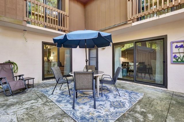 view of patio with outdoor dining space and a balcony