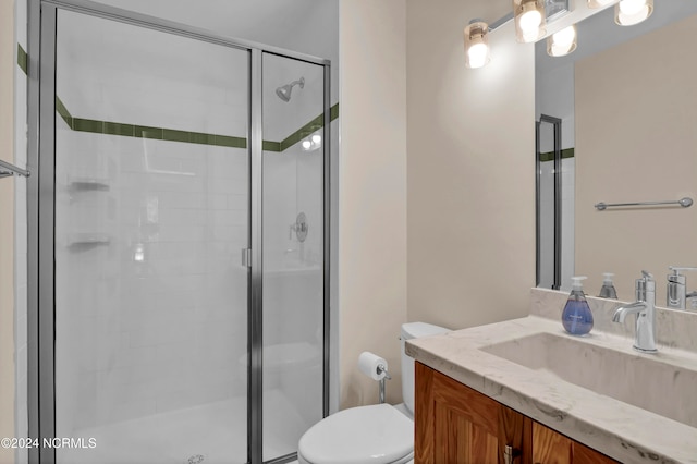 full bath featuring a stall shower, toilet, and vanity