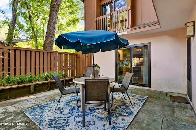 view of patio / terrace with outdoor dining space, a balcony, and fence