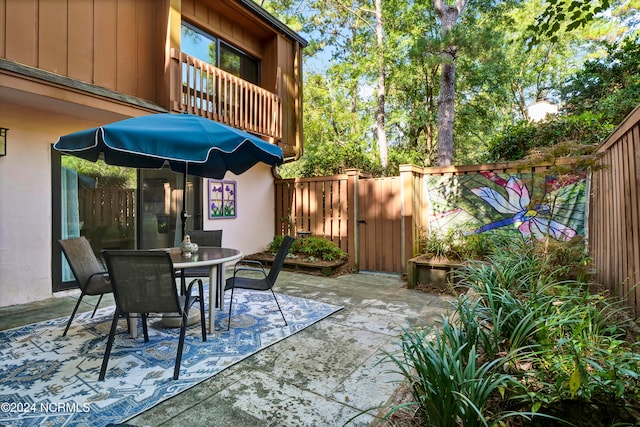 view of patio / terrace featuring outdoor dining area, a balcony, and a fenced backyard