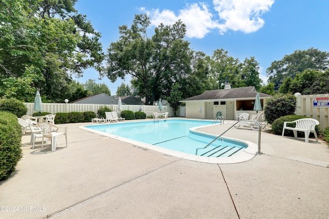 community pool with a patio and fence