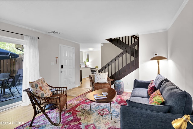 living area featuring light wood-type flooring, visible vents, ornamental molding, stairway, and baseboards