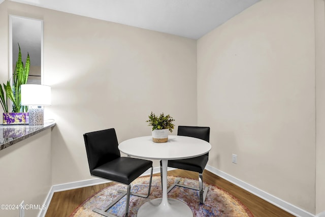 dining space featuring baseboards and wood finished floors