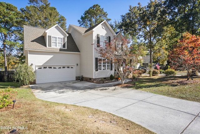 view of front of property featuring a front lawn and a garage