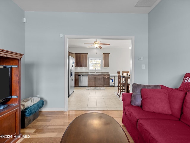 living room with ceiling fan, light hardwood / wood-style flooring, and sink