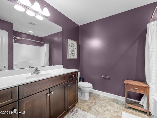 bathroom featuring walk in shower, vanity, and toilet