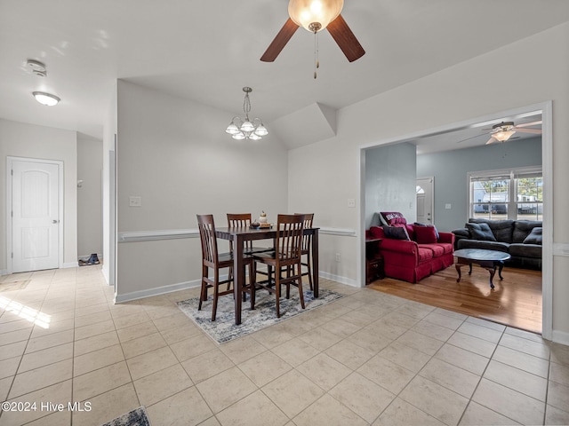 dining area with light tile patterned floors and ceiling fan with notable chandelier