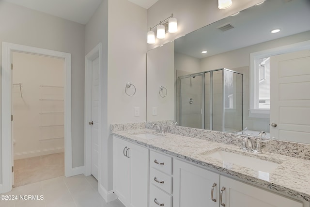 bathroom featuring vanity, tile patterned floors, and walk in shower