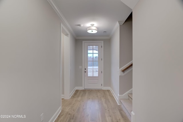 doorway featuring ornamental molding and light wood-type flooring