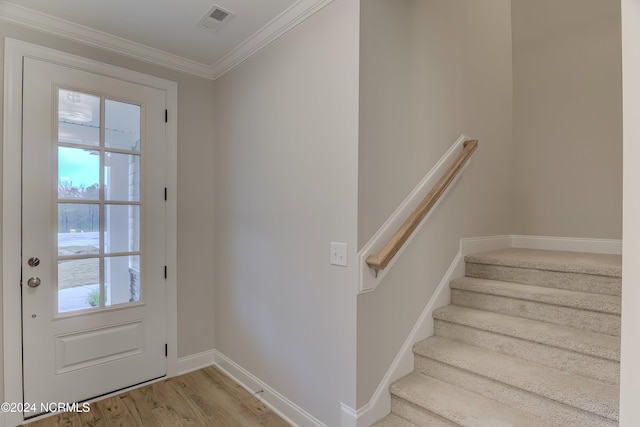 doorway to outside featuring ornamental molding and light wood-type flooring