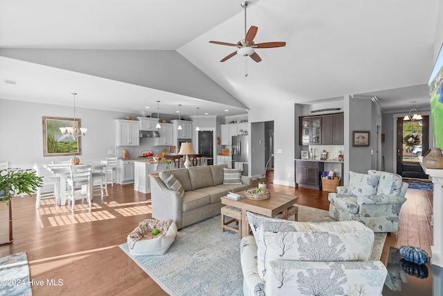 living room featuring dark hardwood / wood-style floors, high vaulted ceiling, and ceiling fan with notable chandelier