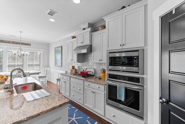 kitchen with white cabinets, hanging light fixtures, sink, a notable chandelier, and stainless steel appliances