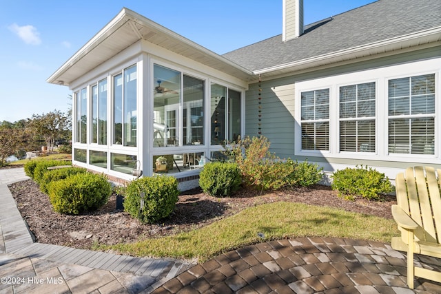 view of property exterior featuring a patio and a sunroom