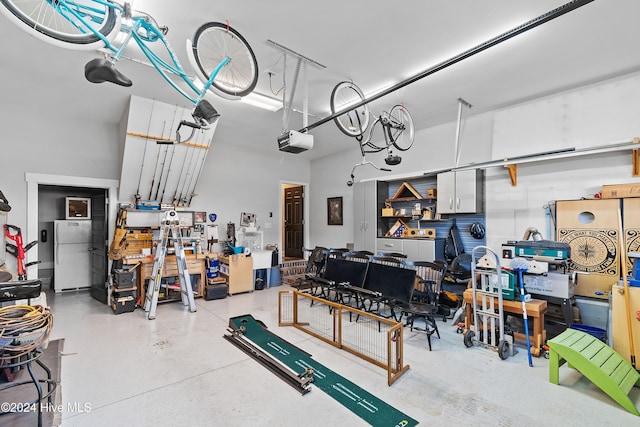 garage with a garage door opener and white fridge