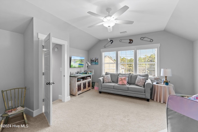 carpeted living room with ceiling fan and vaulted ceiling