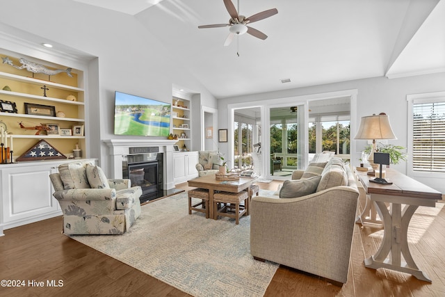 living room featuring ceiling fan, lofted ceiling, dark hardwood / wood-style floors, and built in shelves