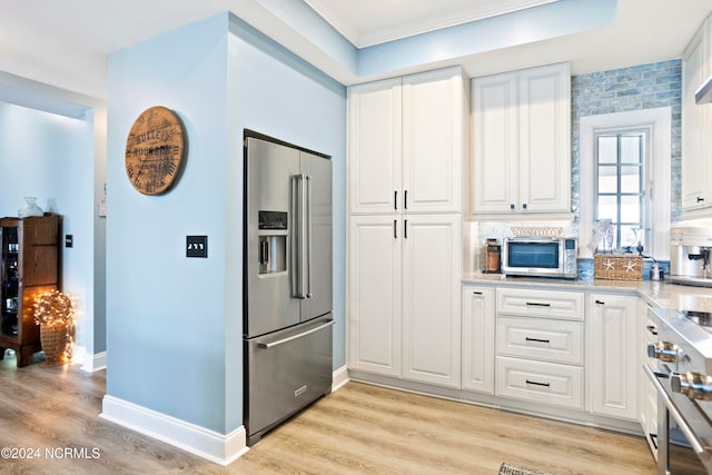 kitchen featuring high quality appliances, white cabinets, and light wood-type flooring