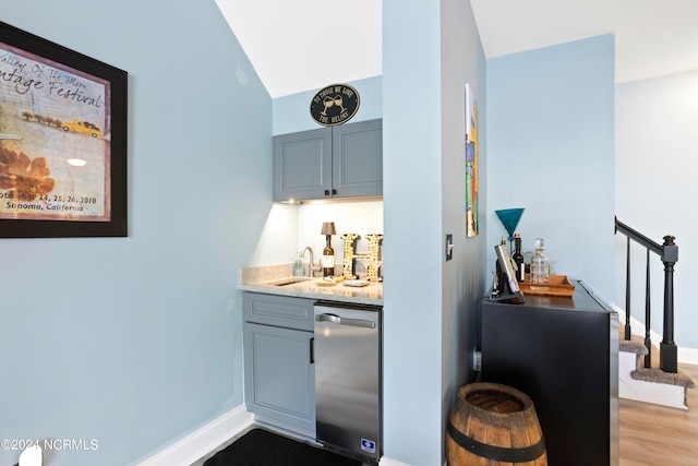 bar with dishwasher, light hardwood / wood-style flooring, sink, vaulted ceiling, and gray cabinets