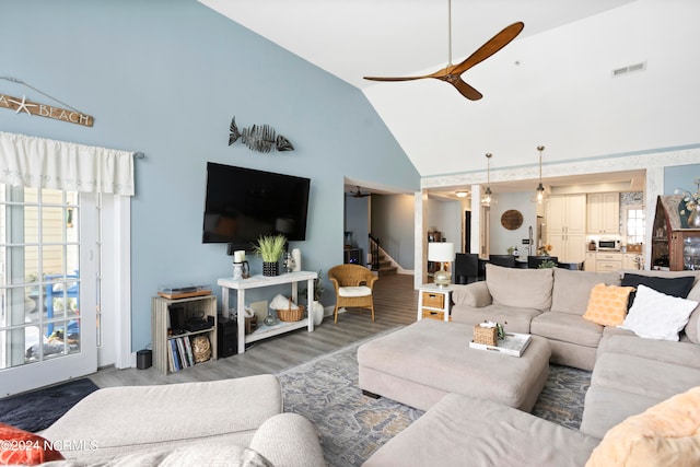 living room featuring dark hardwood / wood-style flooring, high vaulted ceiling, and ceiling fan