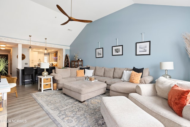 living room with lofted ceiling, hardwood / wood-style floors, and ceiling fan