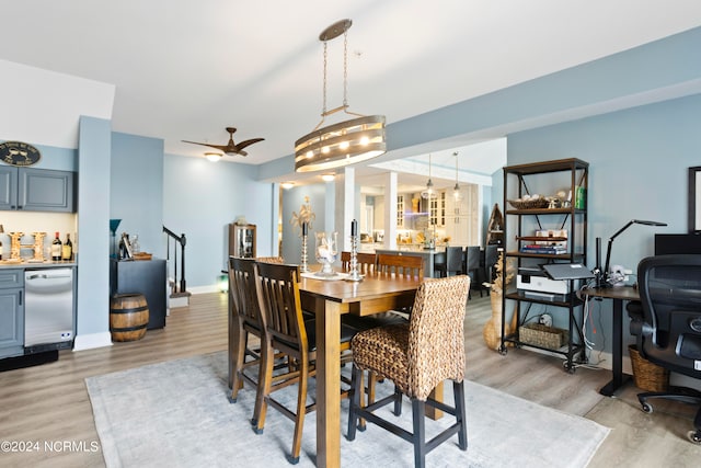 dining space featuring light hardwood / wood-style flooring and ceiling fan with notable chandelier