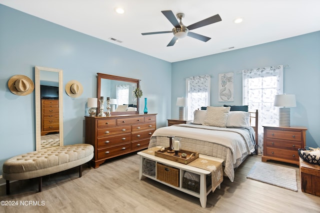 bedroom with light hardwood / wood-style flooring, multiple windows, and ceiling fan