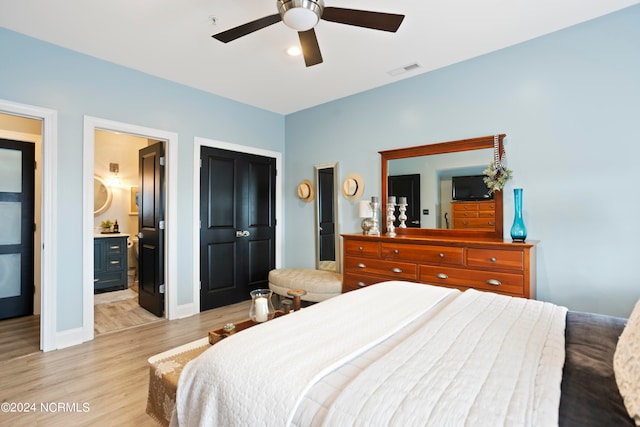 bedroom featuring ceiling fan, light wood-type flooring, and ensuite bath