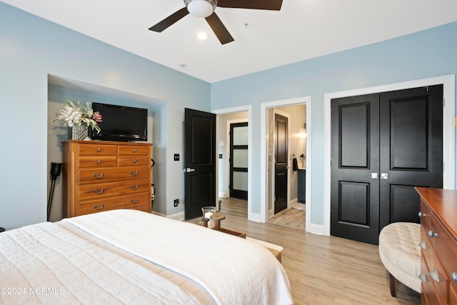 bedroom with light hardwood / wood-style floors, a closet, ensuite bathroom, and ceiling fan