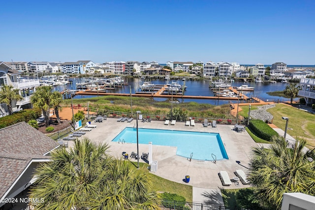 view of pool with a patio and a water view