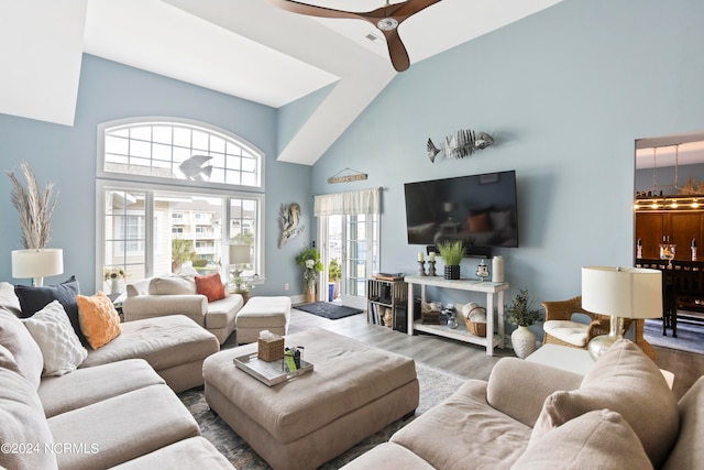 living room featuring ceiling fan, high vaulted ceiling, and wood-type flooring