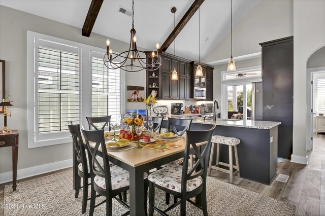 dining room with high vaulted ceiling, visible vents, baseboards, light wood-type flooring, and beamed ceiling