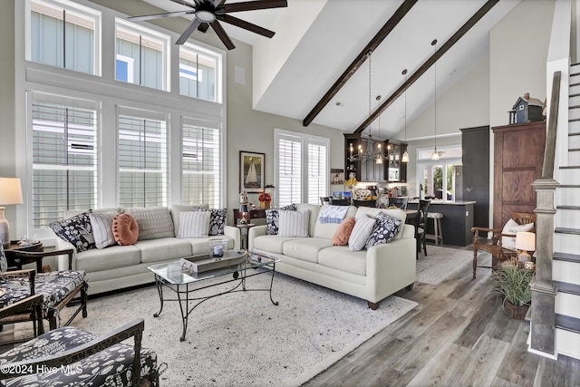 living area featuring high vaulted ceiling, a ceiling fan, beam ceiling, and wood finished floors