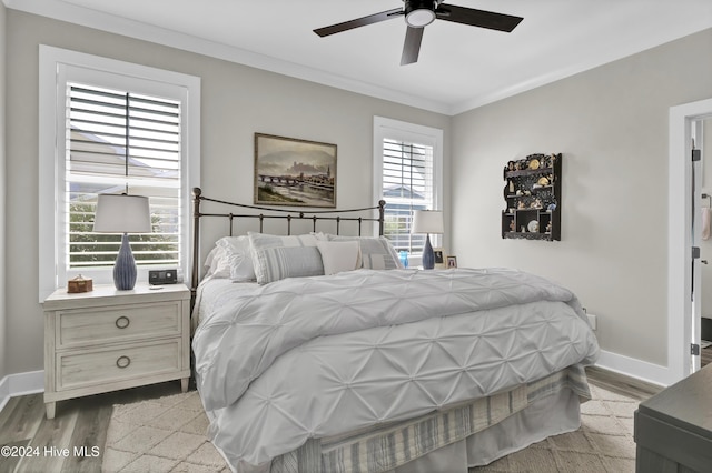 bedroom with ornamental molding, ceiling fan, light wood-style flooring, and baseboards