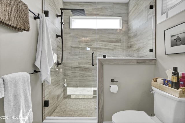 bathroom with a shower stall and toilet